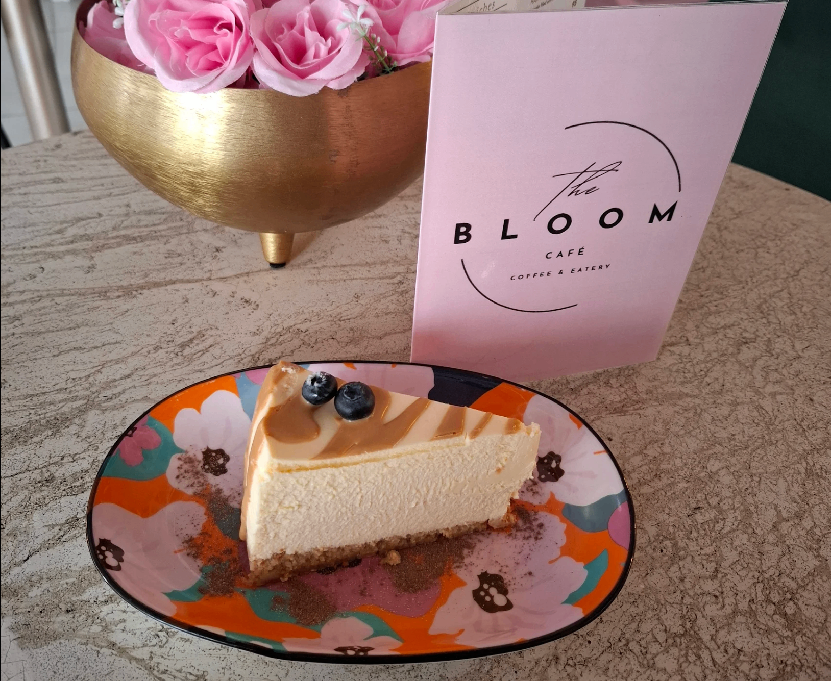 Slice of caramel cheesecake with blueberries at The Bloom Café