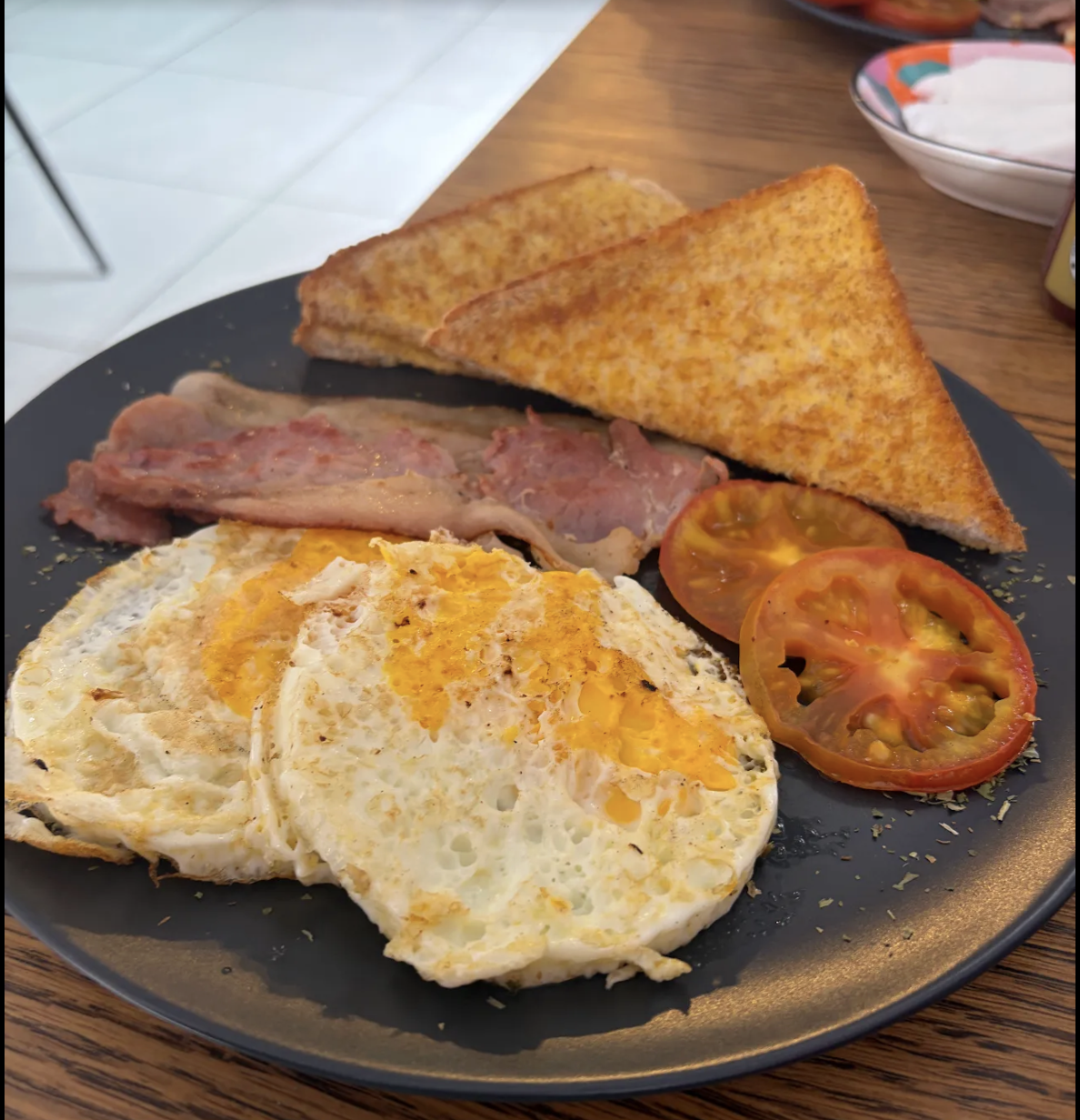 Blooms Special breakfast with fried eggs, bacon, grilled tomato and toast
